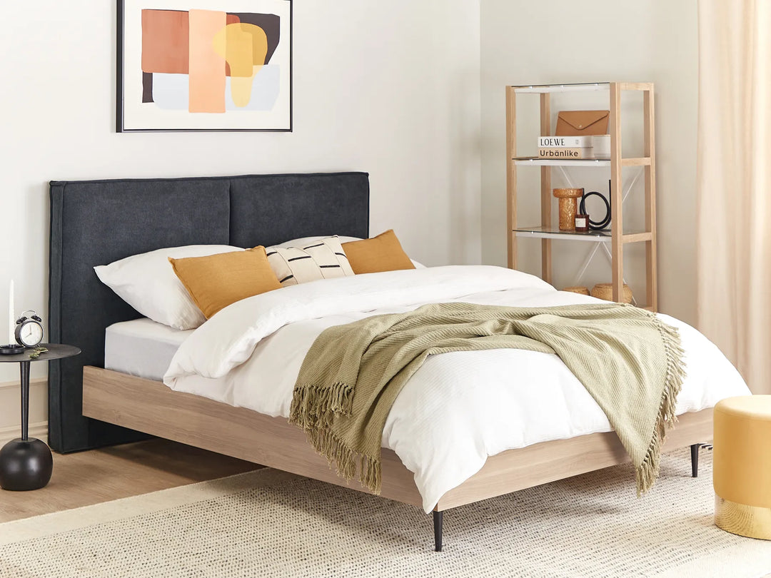 Modern bedroom with a bed, side table, and abstract art on the wall.