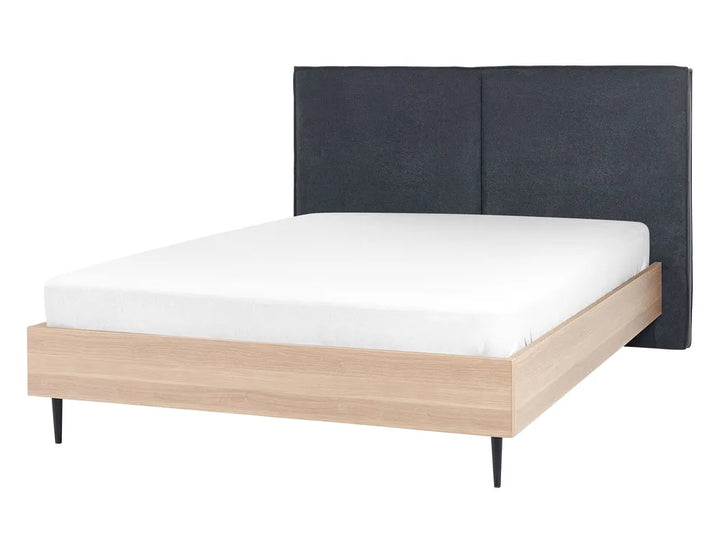 Bed with wooden frame and dark upholstered headboard on a white background