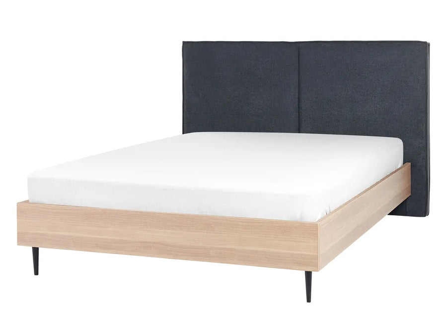Bed with wooden frame and dark upholstered headboard on a white background