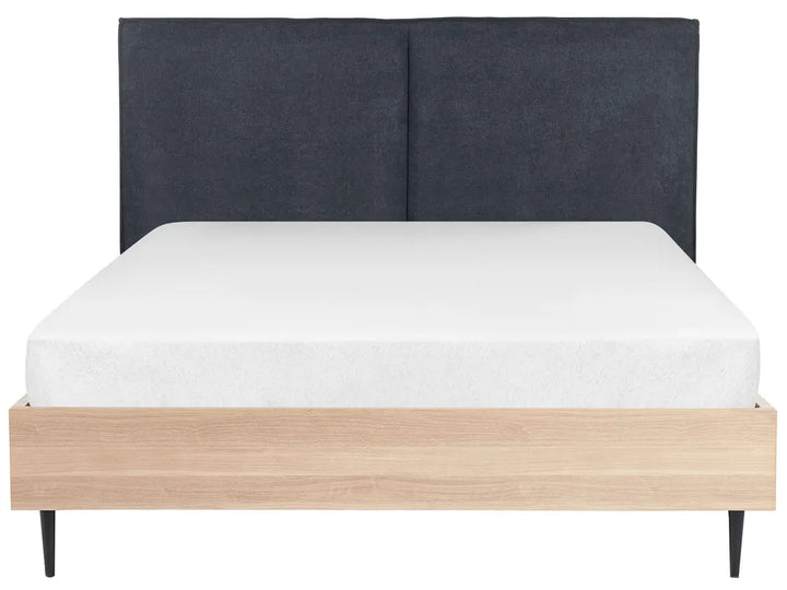 Bed with dark upholstered headboard and light wooden base on a white background
