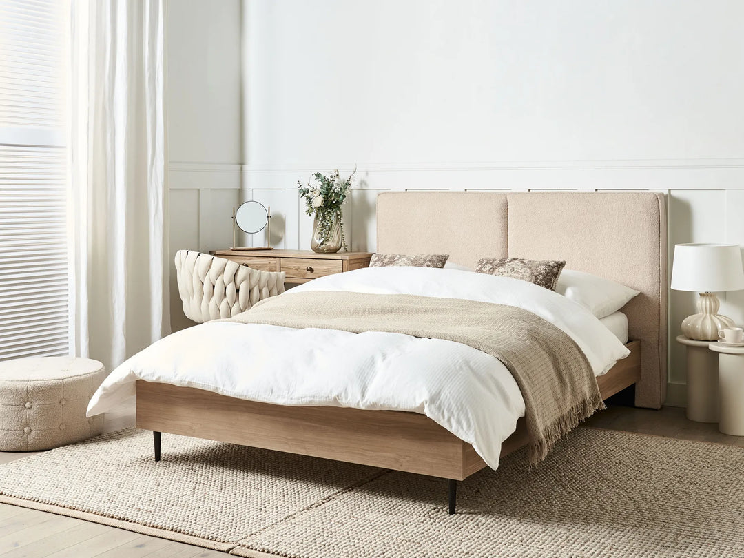 Beige upholstered bed with white bedding in a bedroom setting