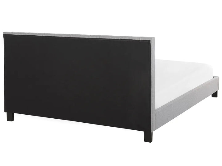 Bed frame with black headboard and white mattress on a white background