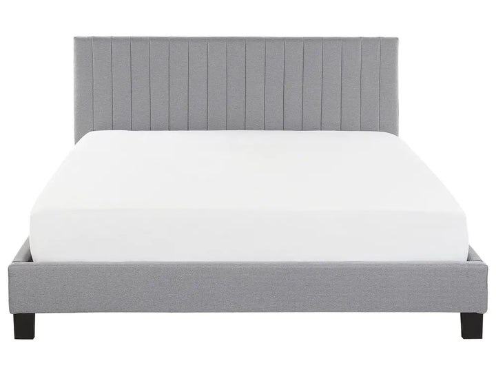 Gray upholstered bed with white mattress on a white background