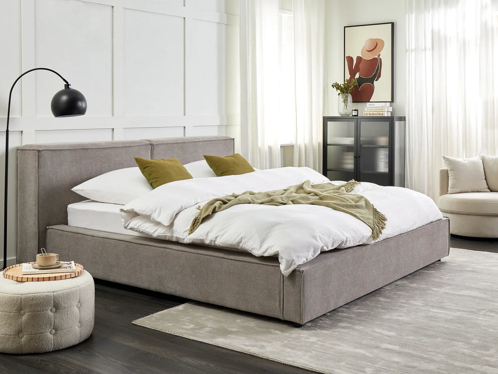 Modern bedroom with a gray upholstered bed, white bedding, and decorative pillows.