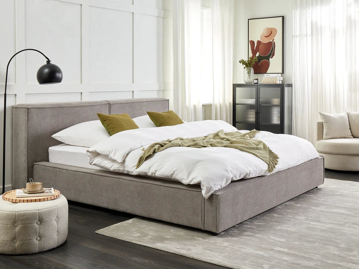 Modern bedroom with a gray upholstered bed, white bedding, and decorative pillows.