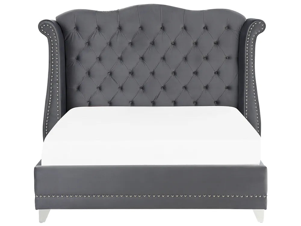 Gray tufted bed with white mattress on a white background