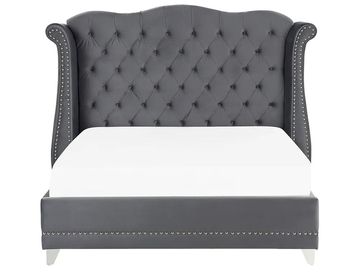 Gray tufted bed with white mattress on a white background