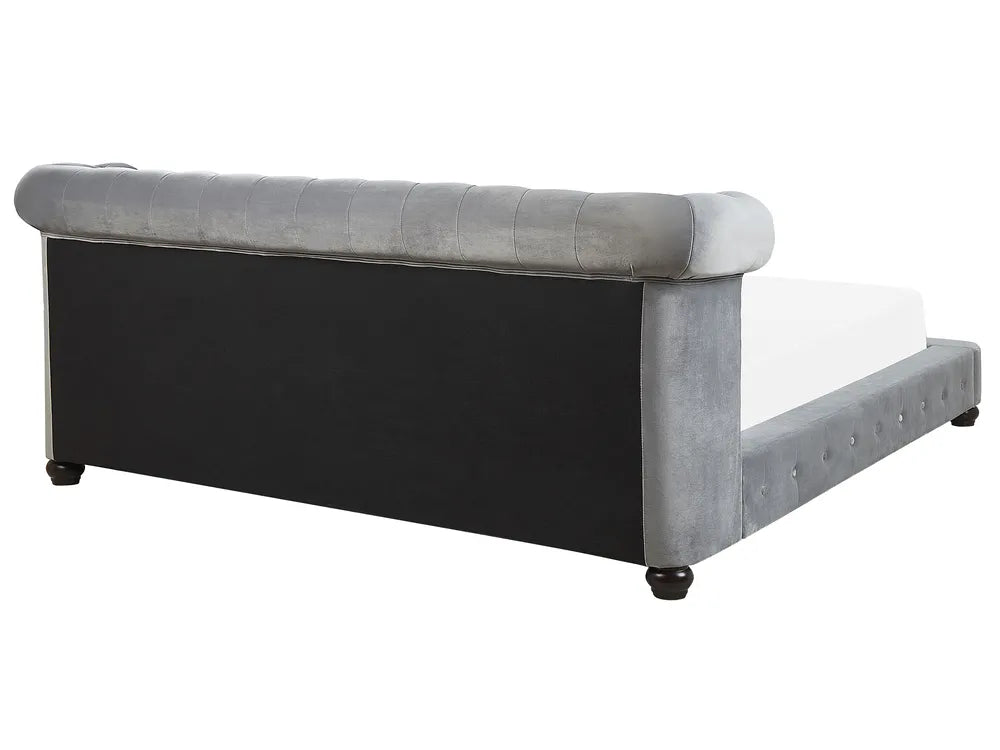 Gray upholstered bed with tufted details on a white background