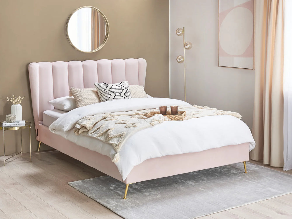 Pink upholstered bed in a bedroom with decor elements.