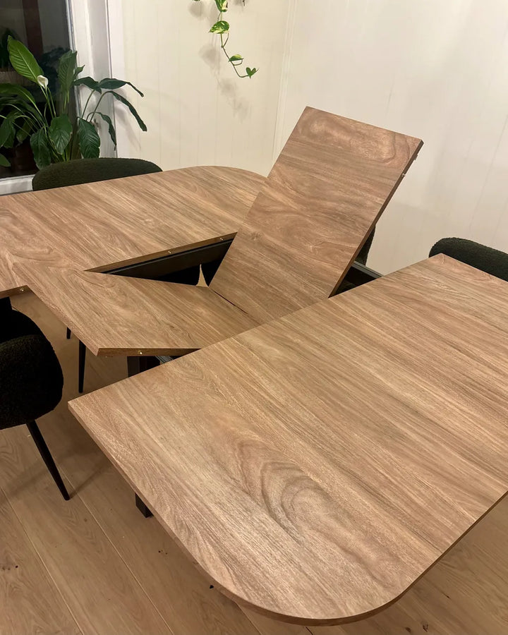 Wooden dining table with chairs in a room with plants
