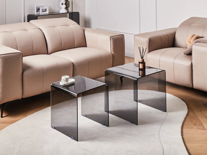 Beige sectional sofa with glass coffee tables in a living room setting.