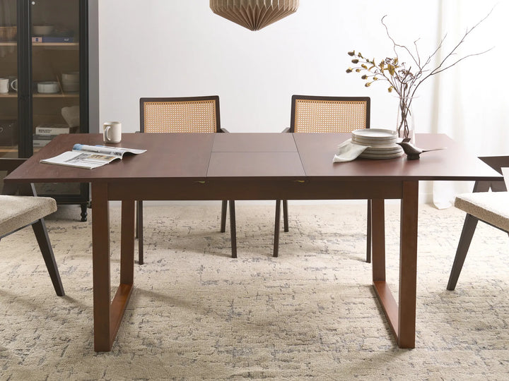 Dining room with a wooden table and chairs on a textured floor.