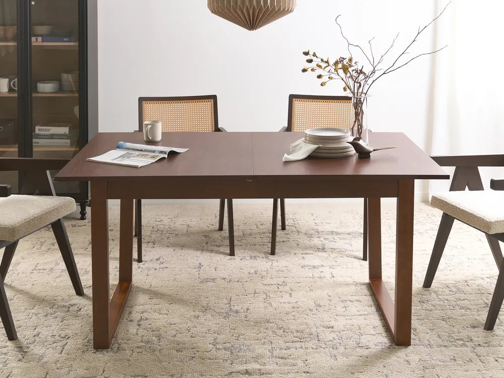 Dining room with a wooden table and chairs on a textured floor.