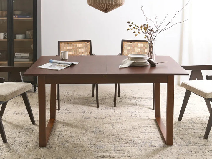 Dining room with a wooden table and chairs on a textured floor.