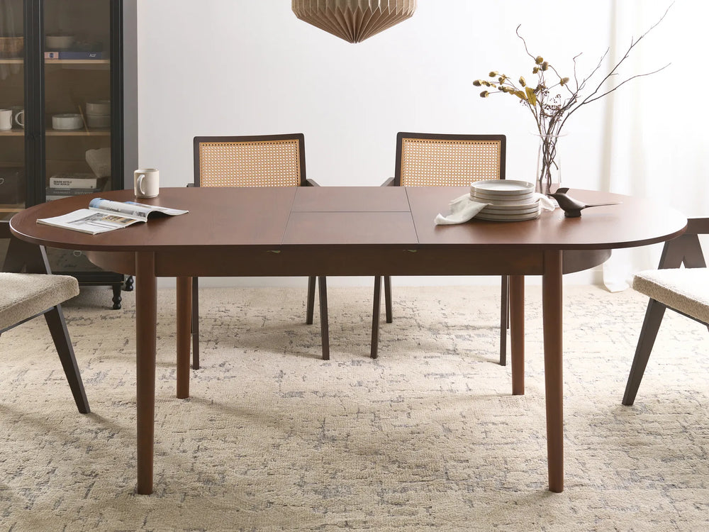 Dining room with a wooden table and chairs, featuring a vase with flowers and plates.