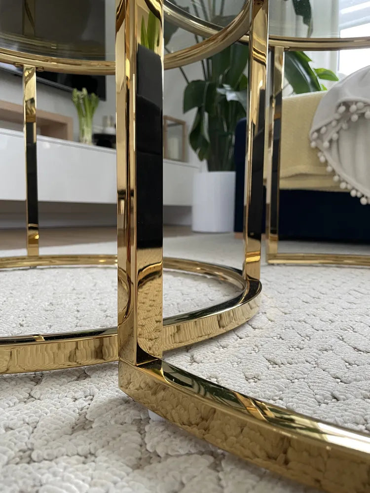 Gold-framed mirrors on a textured surface with a blurred indoor setting
