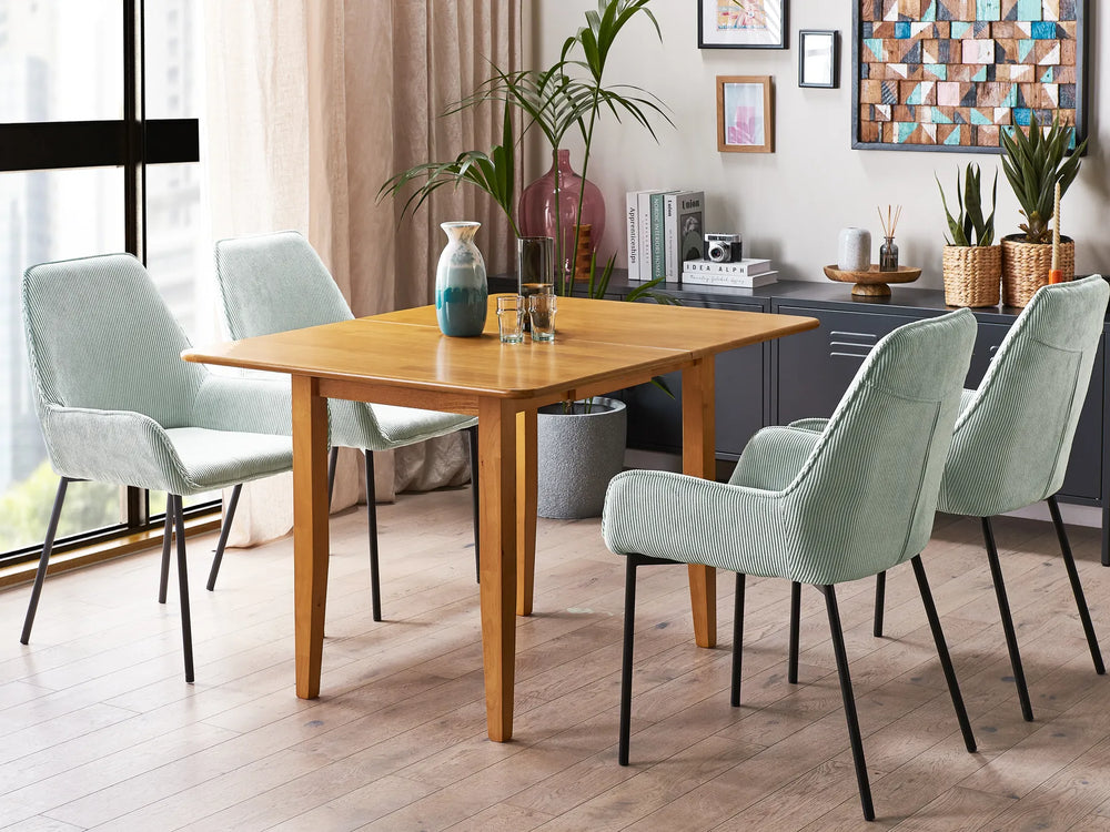 Dining area with wooden table and light green chairs in a modern kitchen.
