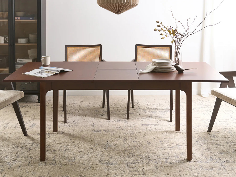 Dining room with a wooden table and chairs on a textured rug.