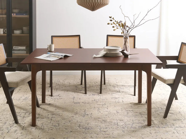 Dining room with a wooden table and chairs on a textured rug.