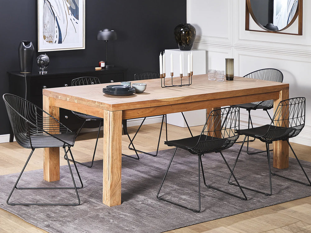 Dining room with wooden table and black chairs on a gray rug.