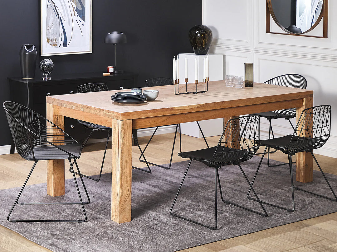 Dining room with wooden table and black chairs on a gray rug.