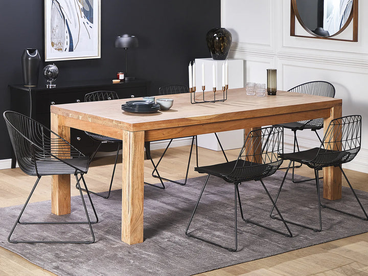 Dining room with wooden table and black chairs on a gray rug.