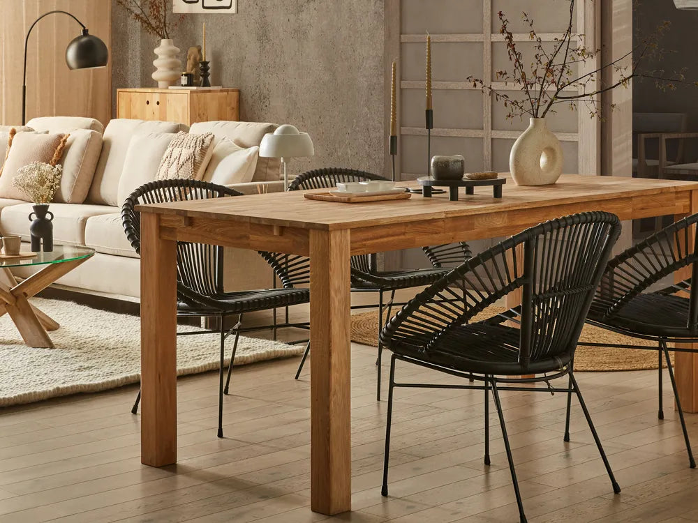 Dining area with wooden table and black chairs in a living room setting.