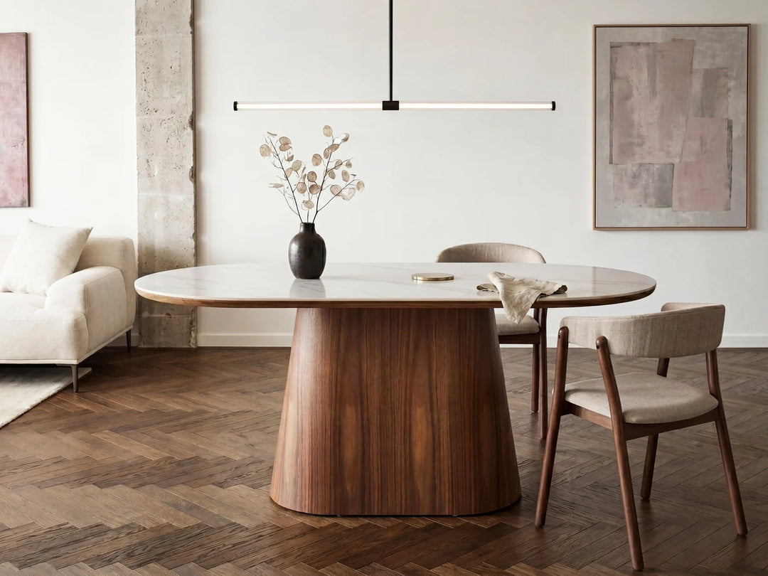 Dining room with a wooden table and chairs, vase with flowers, and abstract art on the wall.