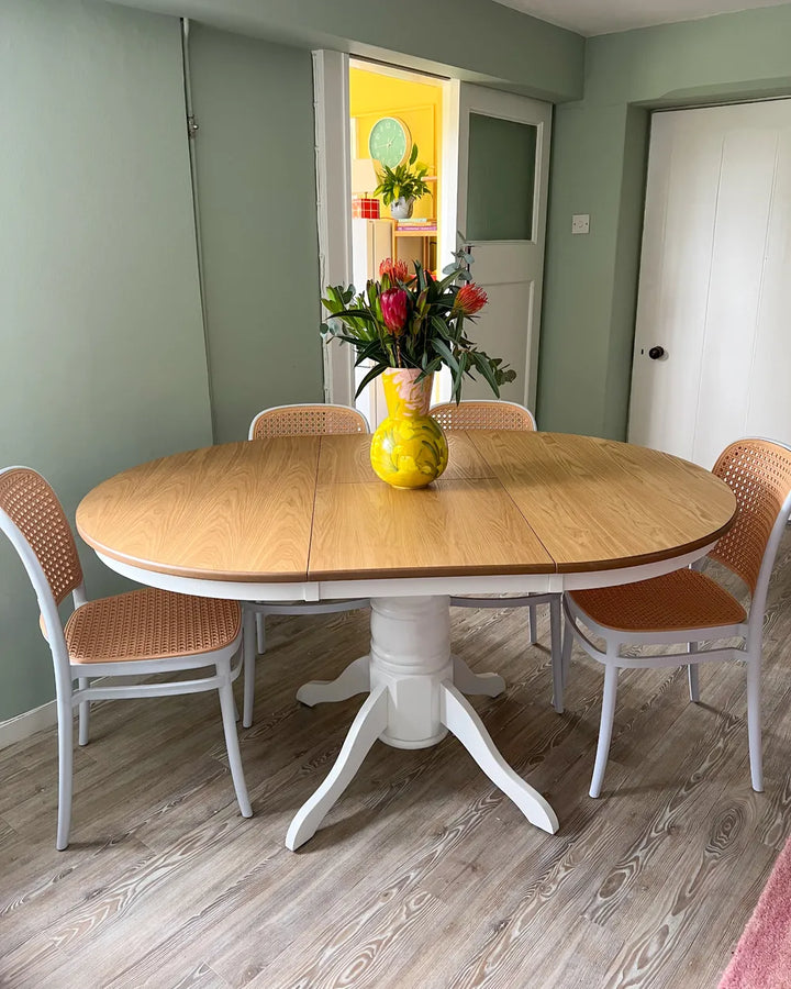 Dining room with a wooden table and chairs on a wooden floor.