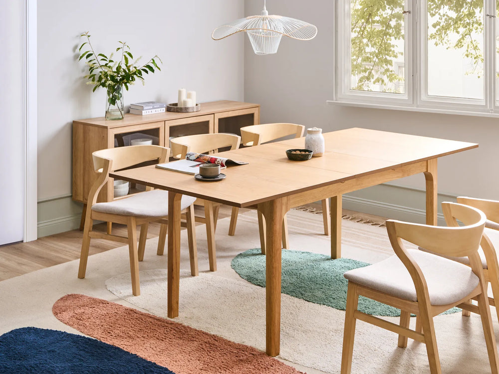 Dining room with wooden table and chairs, sideboard, and decorative elements.