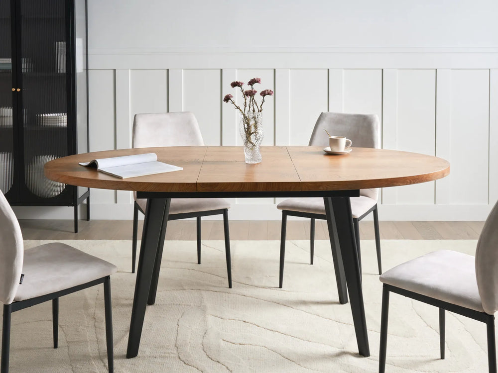 Dining table with chairs in a room with a white wall and black cabinet.