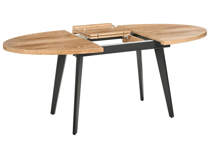 Wooden dining table with black metal legs on a white background