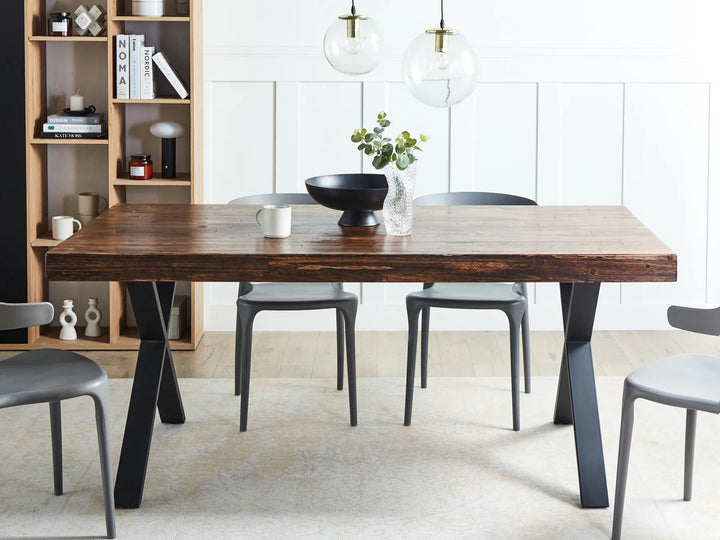 Dining room with a wooden table and gray chairs in a modern interior setting.