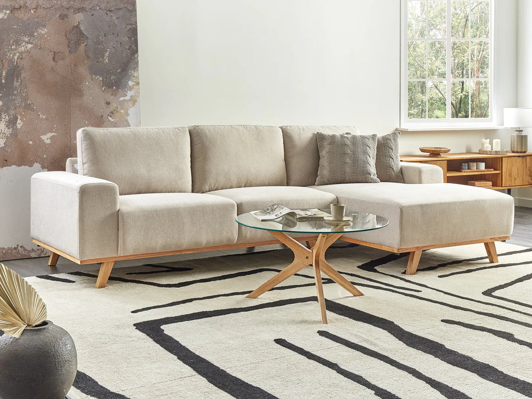 Beige sectional sofa in a living room with a coffee table and decorative items.