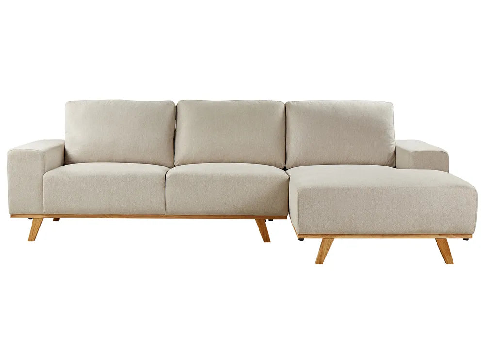 Beige sectional sofa with wooden legs on a white background