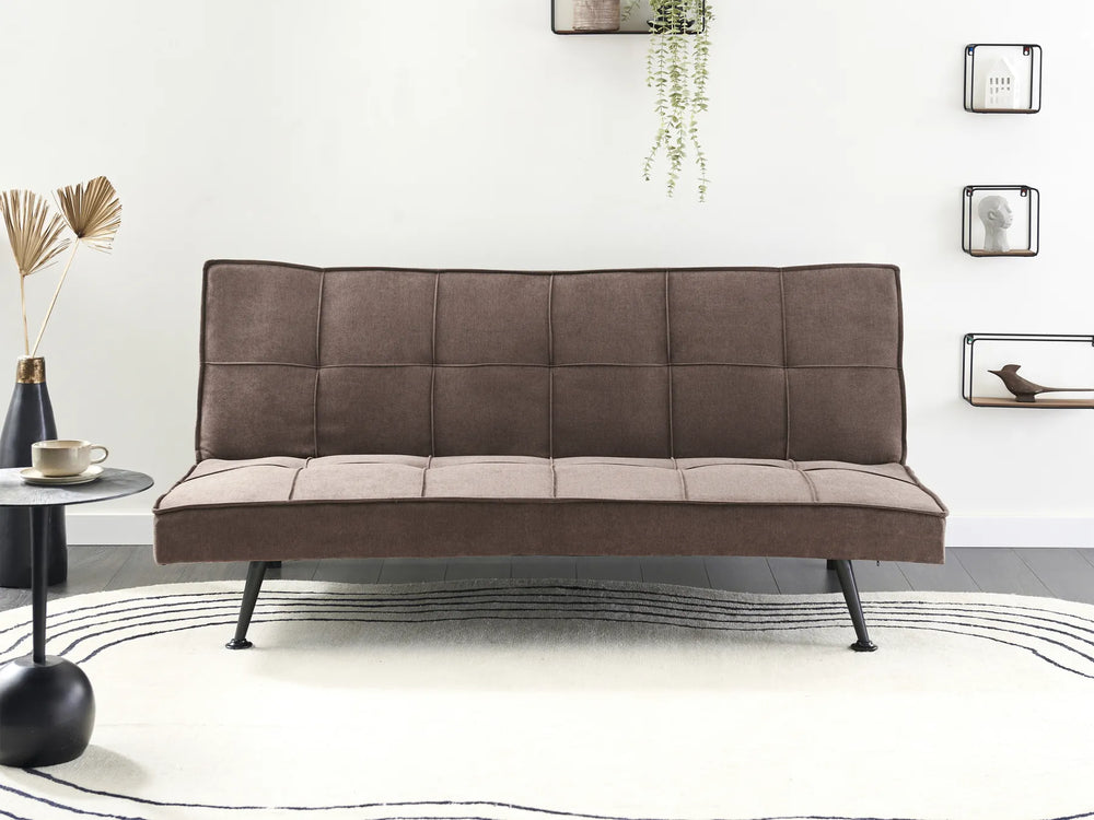 Brown sofa bed in a room with a white wall and decorative elements.