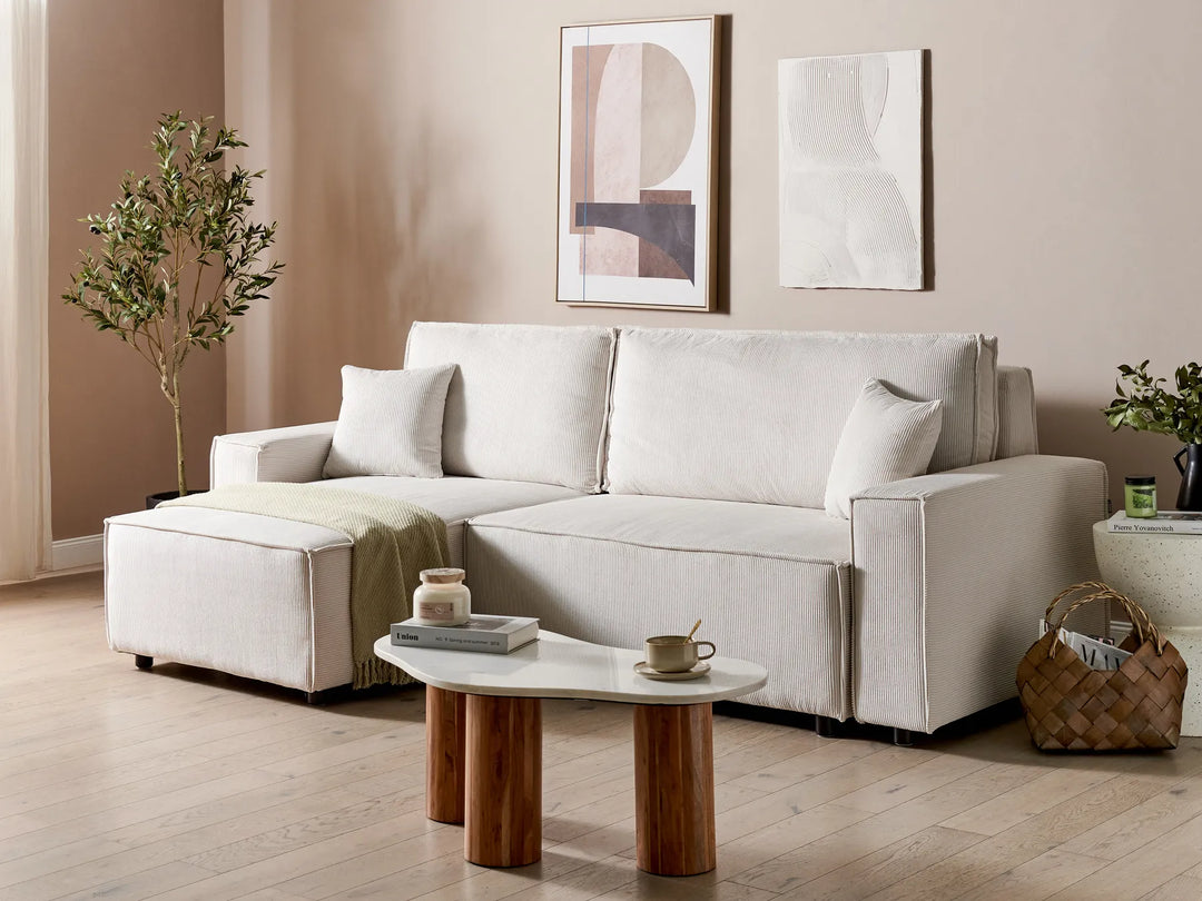 White sectional sofa in a living room with a coffee table and decorative items.