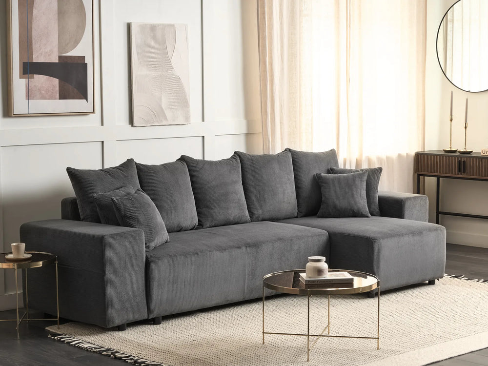 Gray sectional sofa in a living room with abstract art and a coffee table.
