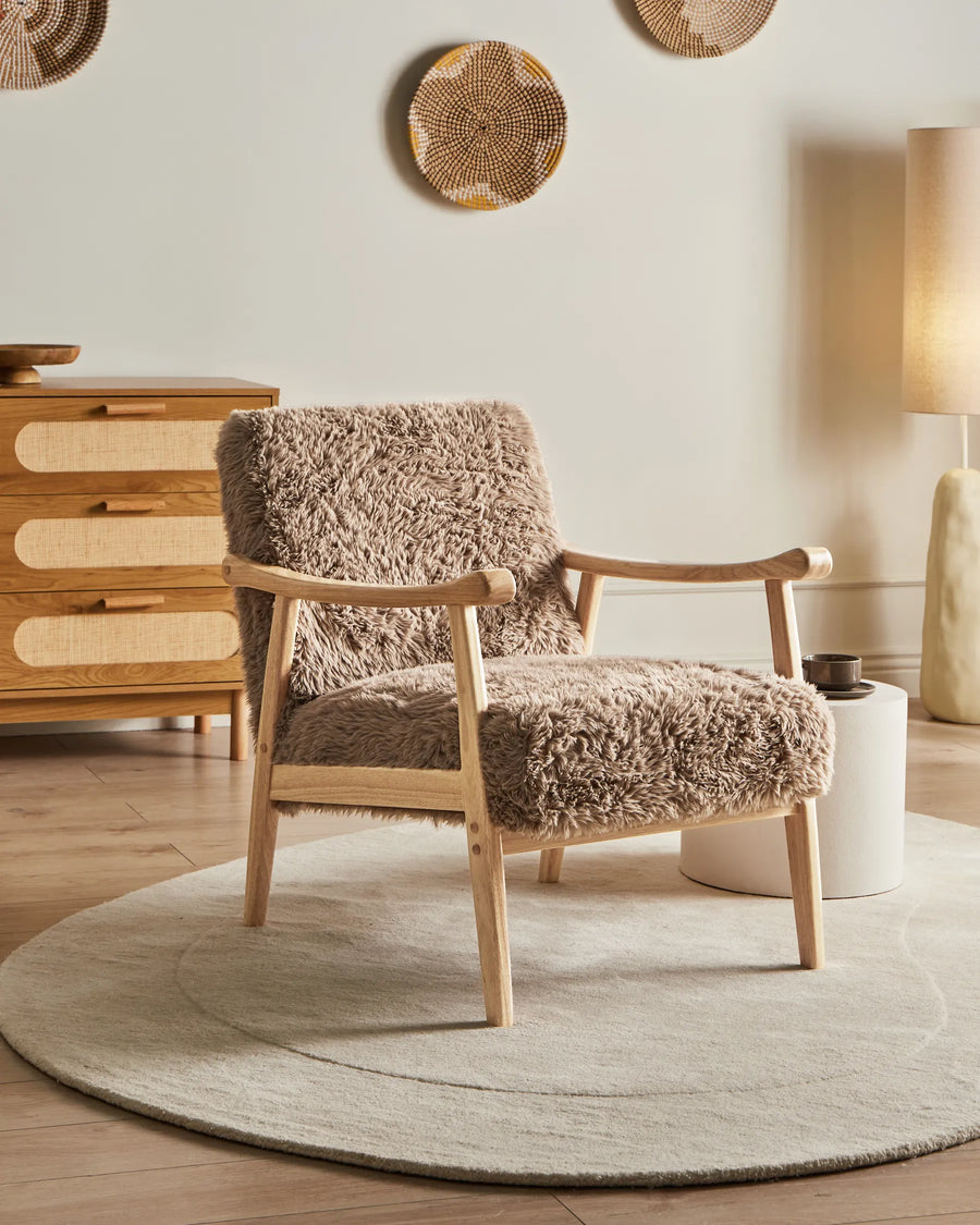 Fluffy armchair in a room with wooden furniture and decorative elements.