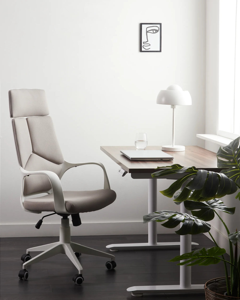 Modern office chair in a minimalistic office setting with a desk and plant.