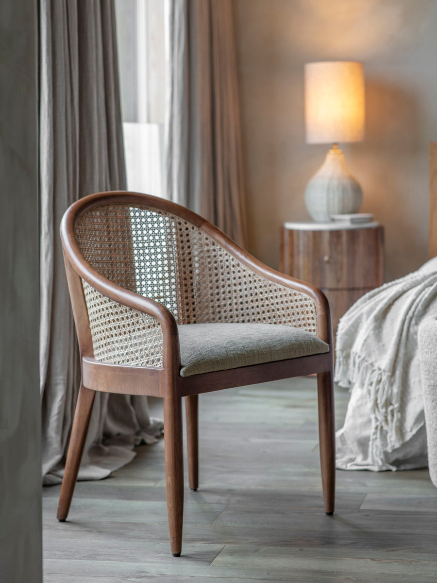 Wicker chair with a cushion in a bedroom setting