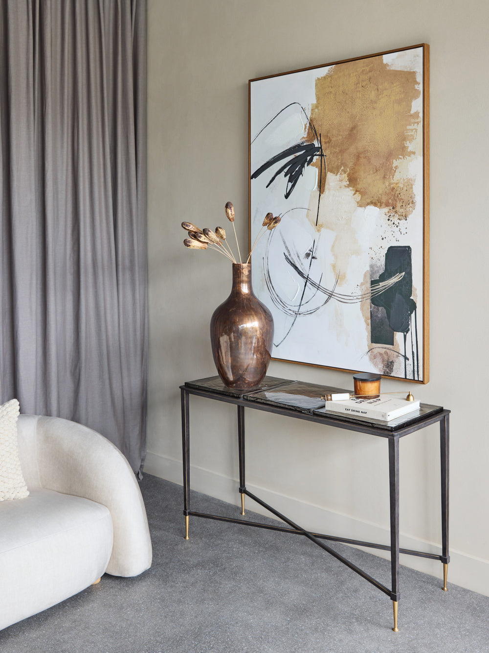 Modern interior with a console table, vase, and abstract painting in a living room.