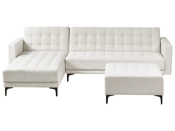 White tufted sectional sofa with ottoman on a white background