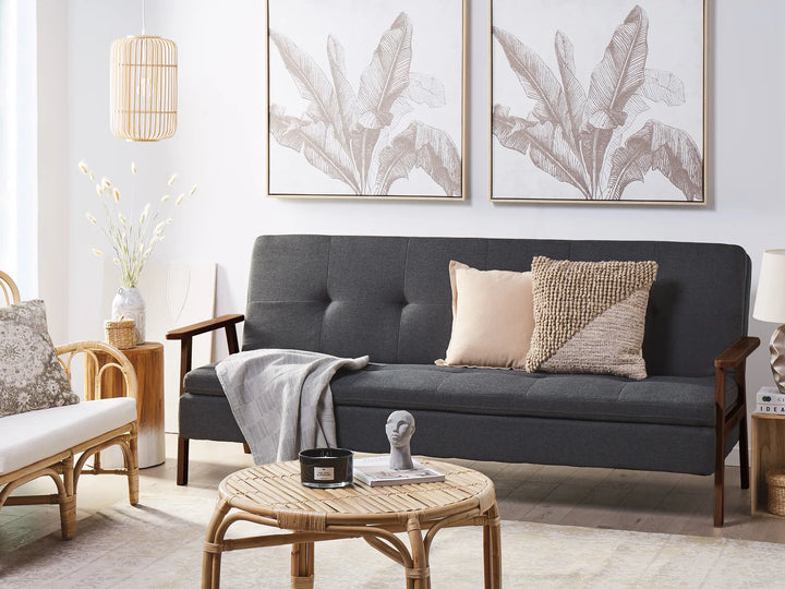 Living room with a gray sofa, wicker coffee table, and decorative elements.