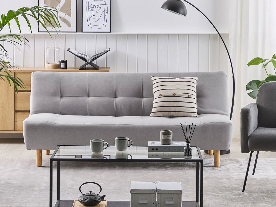 Gray sofa in a living room with a coffee table and decorative items.