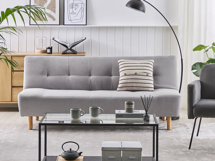 Gray sofa in a living room with a coffee table and decorative items.