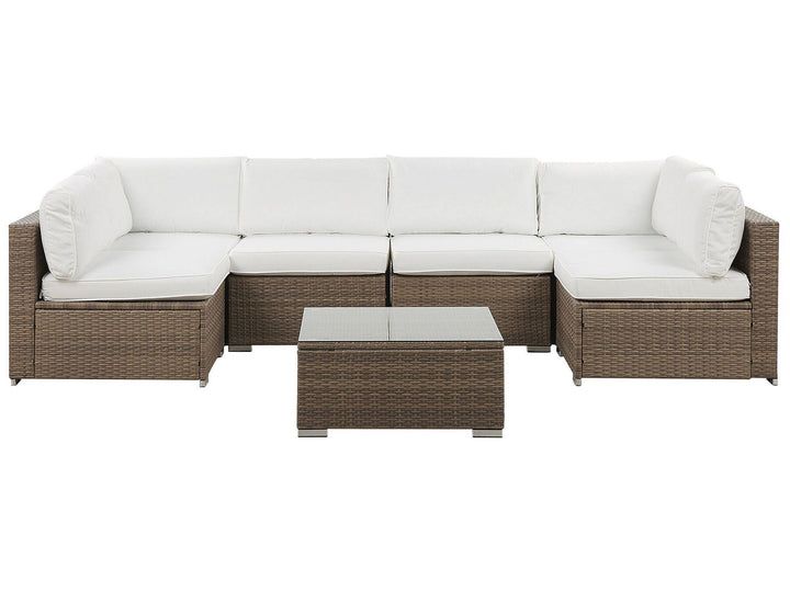 A six-seater modular corner sofa with white cushions and a brown rattan frame, accompanied by a square coffee table with a glass top.