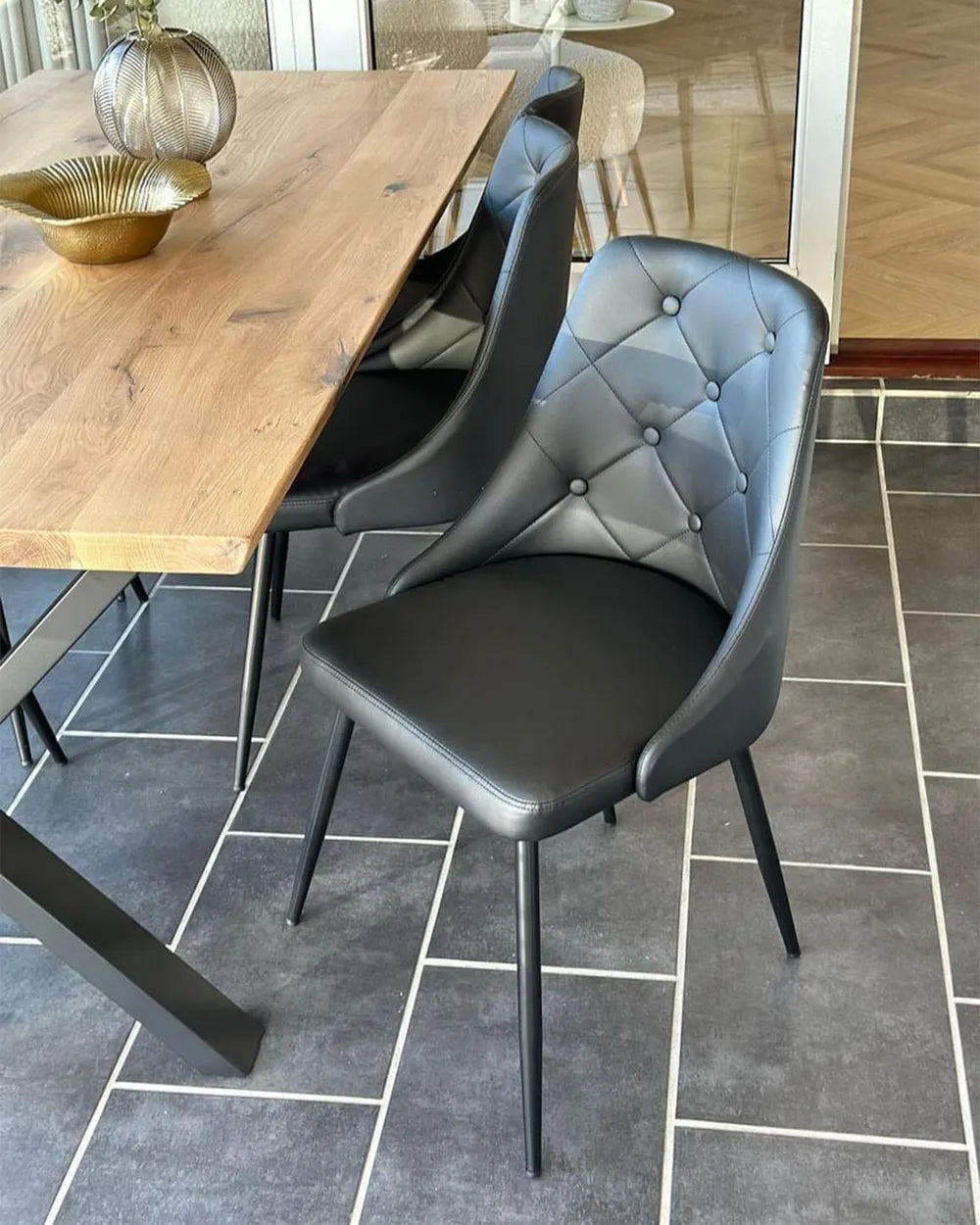 Black faux leather dining chairs with padded seats