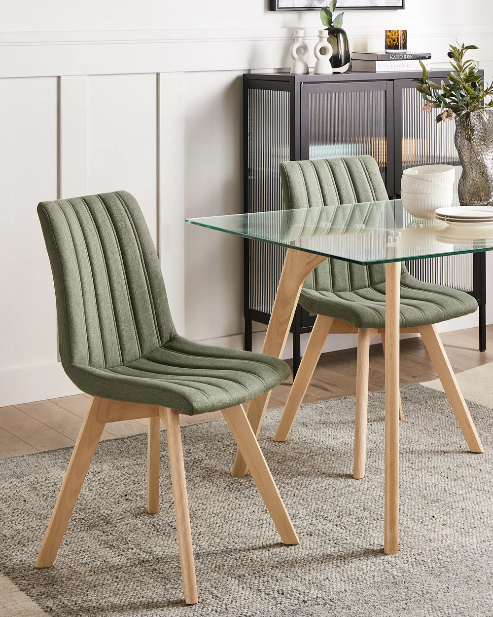Dining table with green chairs in a room setting