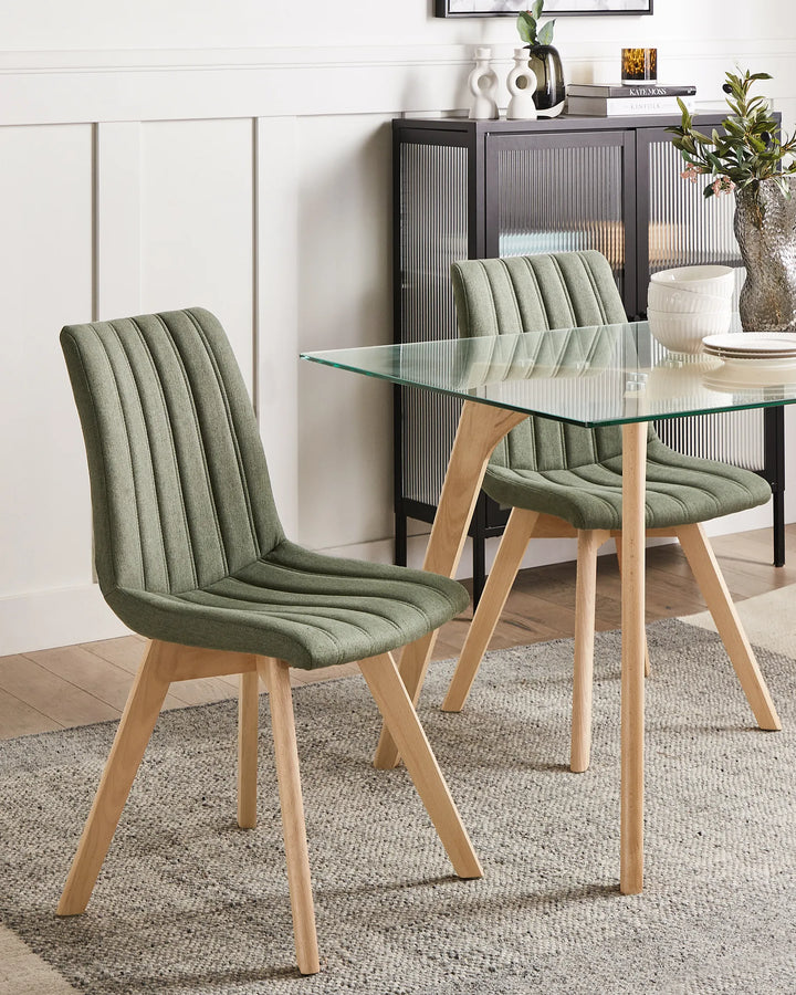 Dining table with green chairs in a room setting